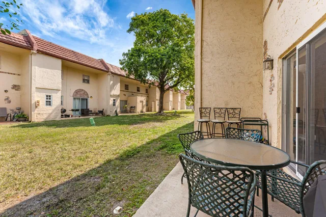 a backyard of a house with yard table and chairs