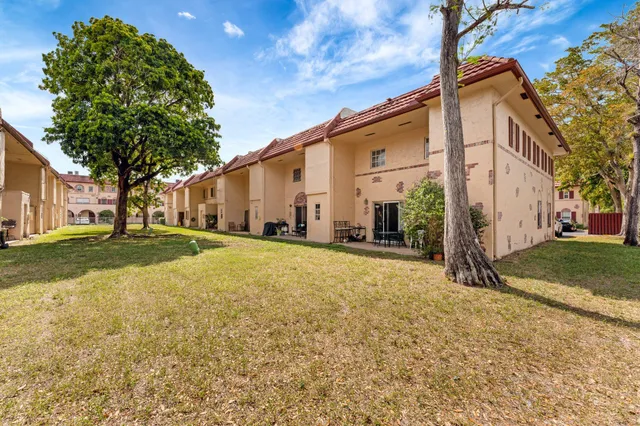 a view of a house with backyard and tree