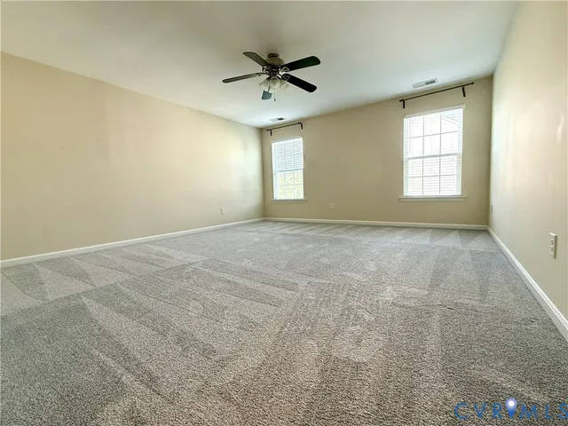 an empty room with a ceiling fan and window