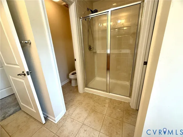 a bathroom with a glass door shower and toilet
