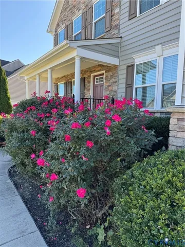 a bunch of flowers and flowers in front of house