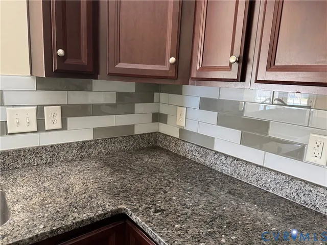 a view of a sink a microwave and cabinets