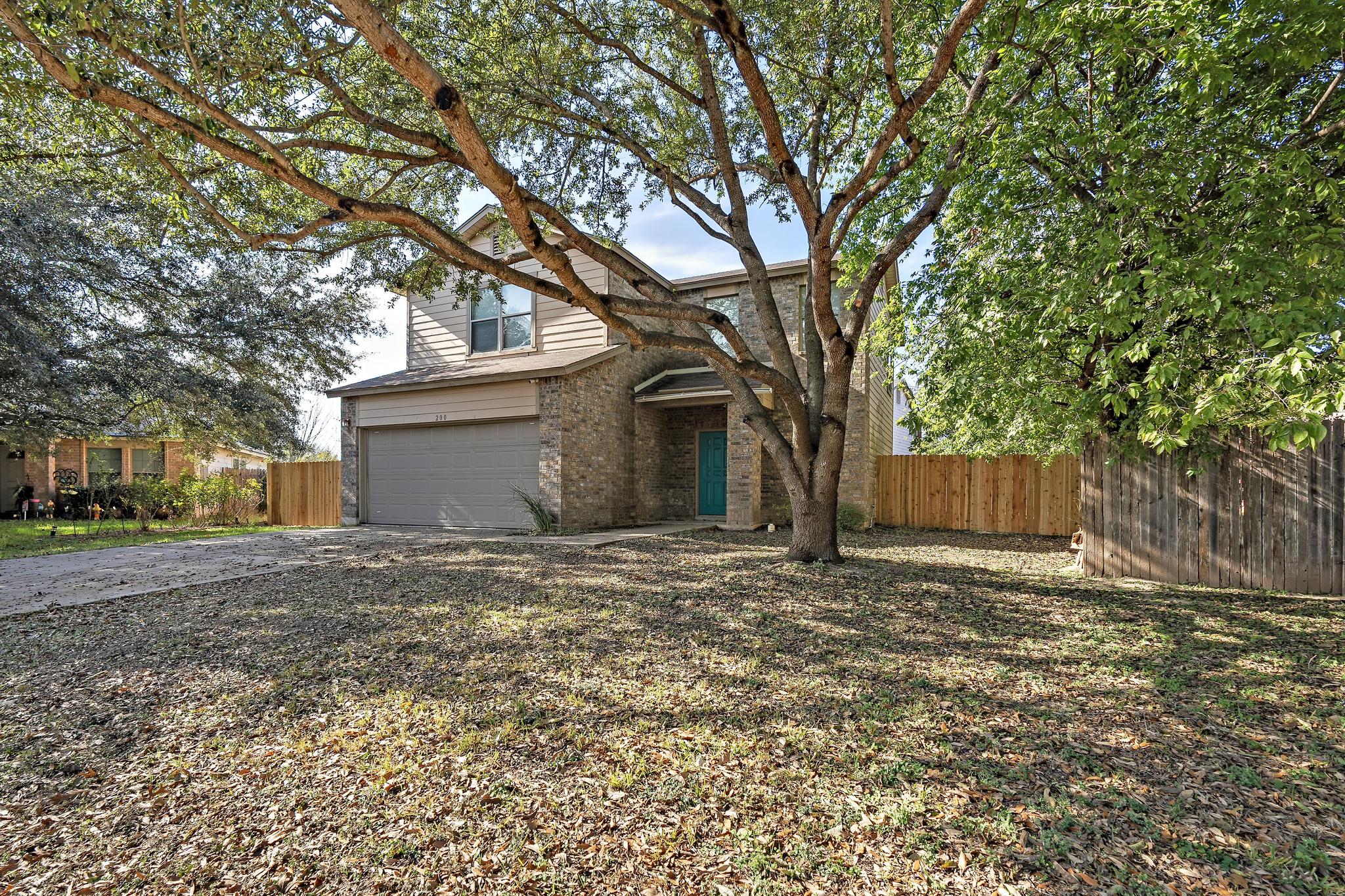 View of front of property featuring brick siding, a garage, and driveway