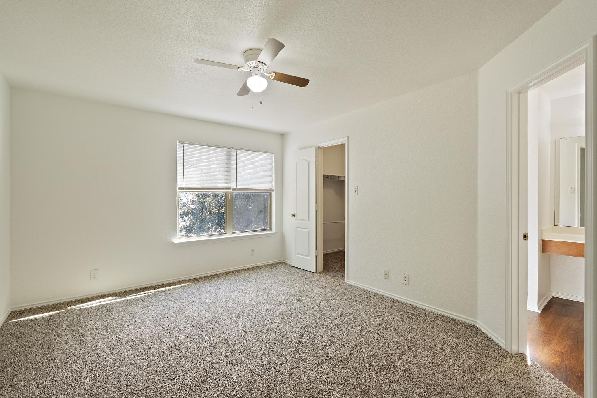 200 Lexington Kyle, TX 78640 - Photo 13 of 25 Unfurnished bedroom featuring a walk in closet, carpet floors, and ceiling fan