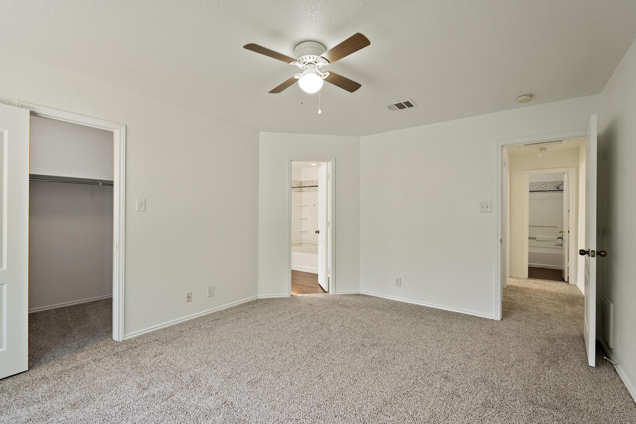 200 Lexington Kyle, TX 78640 - Photo 14 of 25 Unfurnished bedroom featuring light colored carpet, a spacious closet, a ceiling fan, and ensuite bath