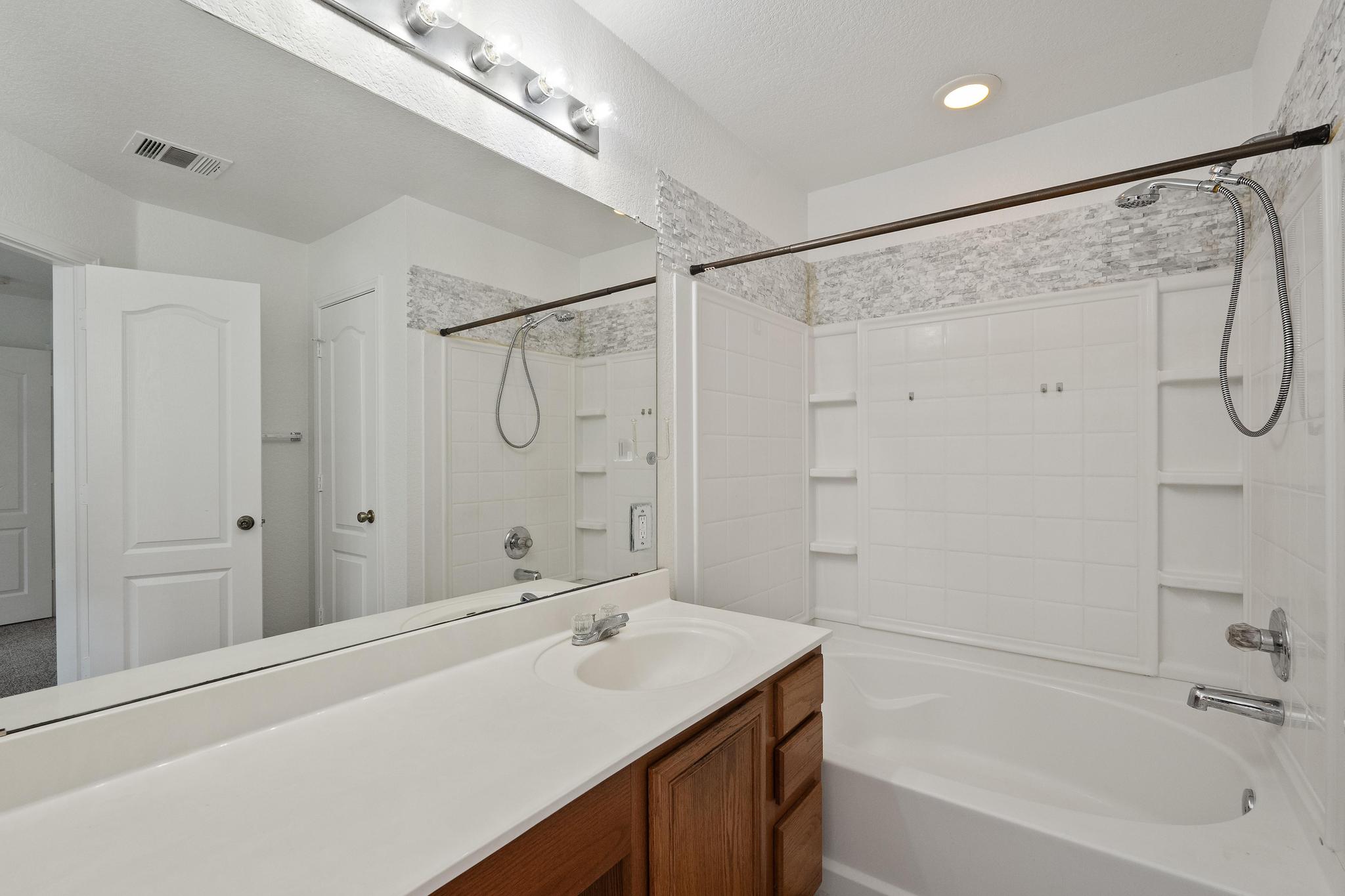 200 Lexington Kyle, TX 78640 - Photo 16 of 25 Bathroom featuring vanity, shower / tub combination, and a textured ceiling