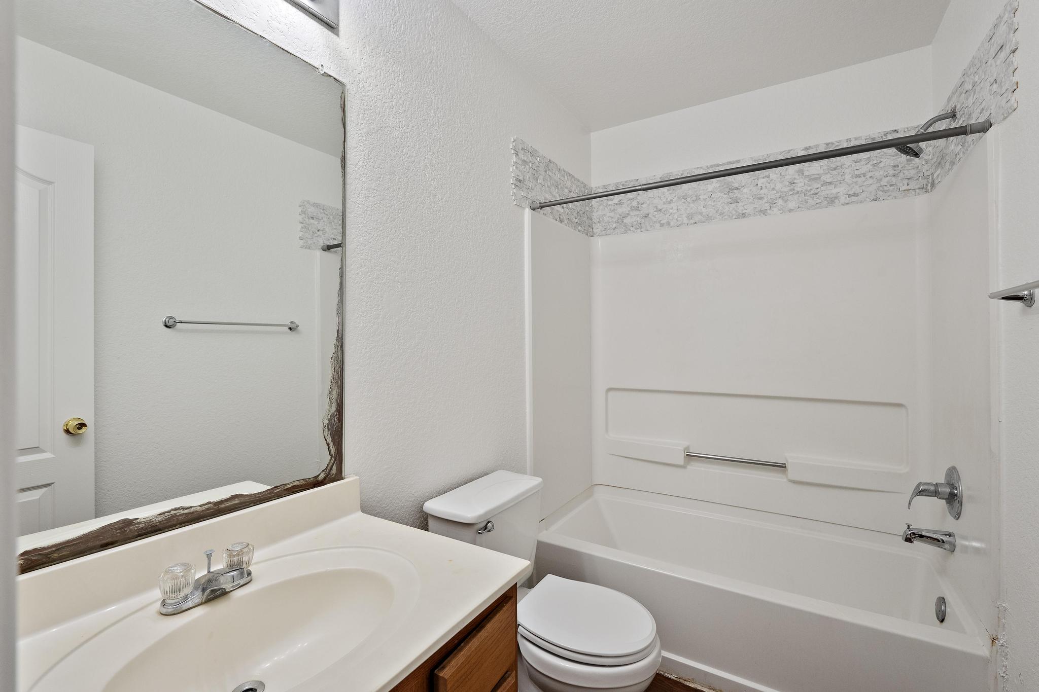 200 Lexington Kyle, TX 78640 - Photo 22 of 25 Full bathroom with vanity, bathtub / shower combination, and a textured wall