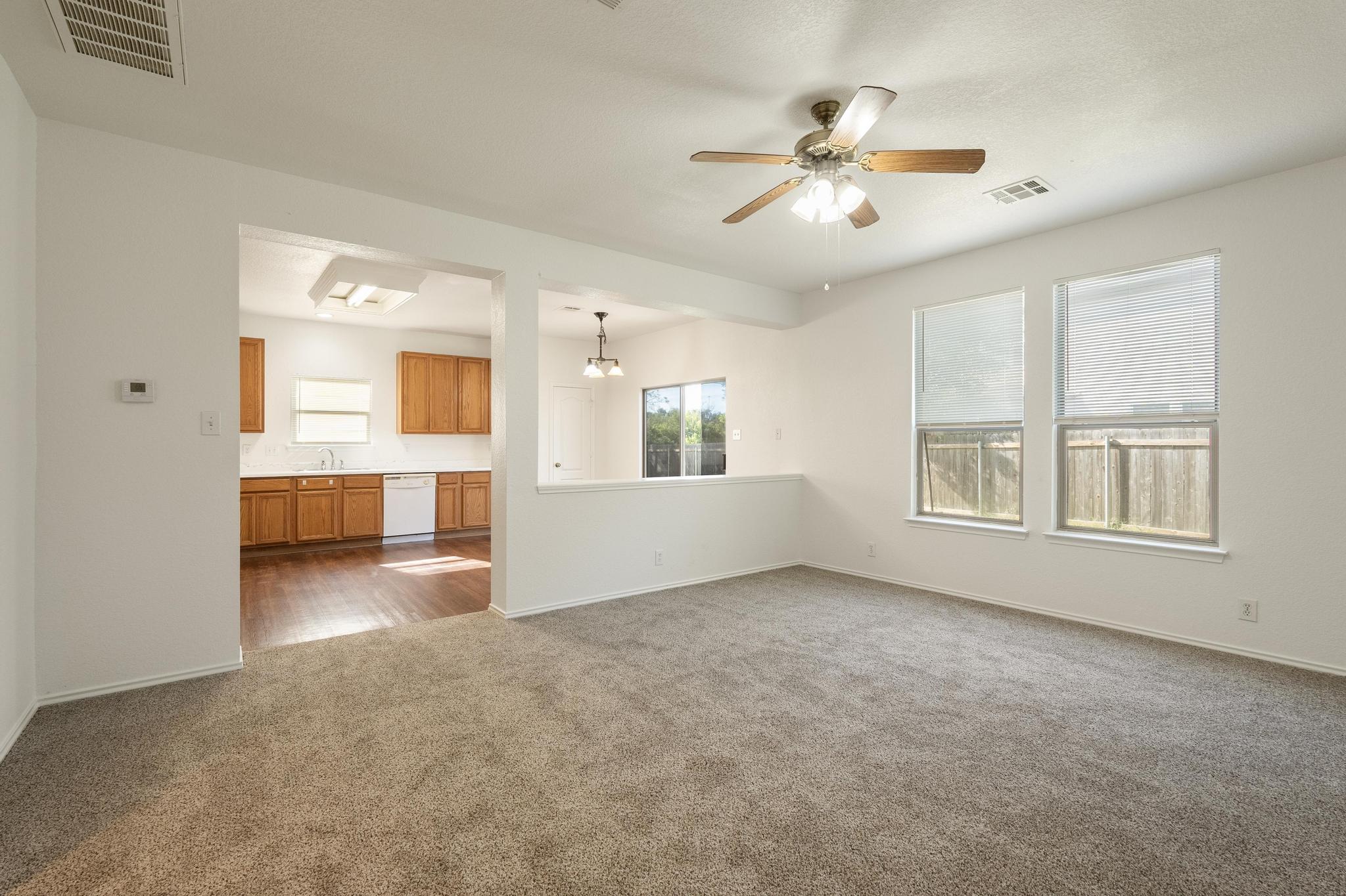 200 Lexington Kyle, TX 78640 - Photo 3 of 25 Unfurnished living room featuring a ceiling fan and dark colored carpet