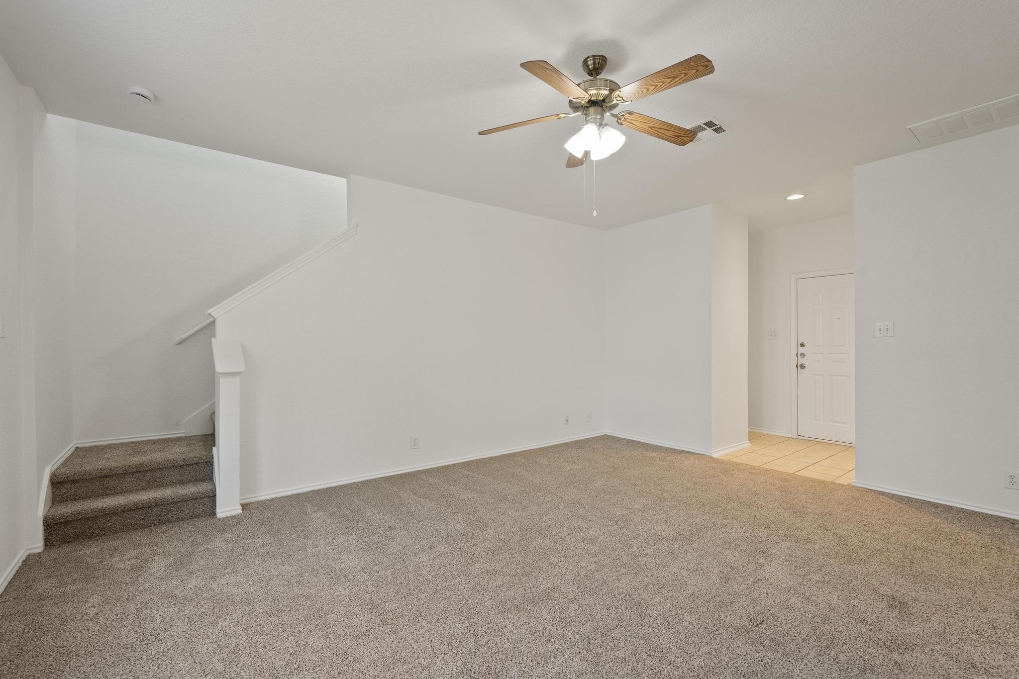 200 Lexington Kyle, TX 78640 - Photo 5 of 25 Unfurnished living room featuring light colored carpet, stairs, ceiling fan, and recessed lighting
