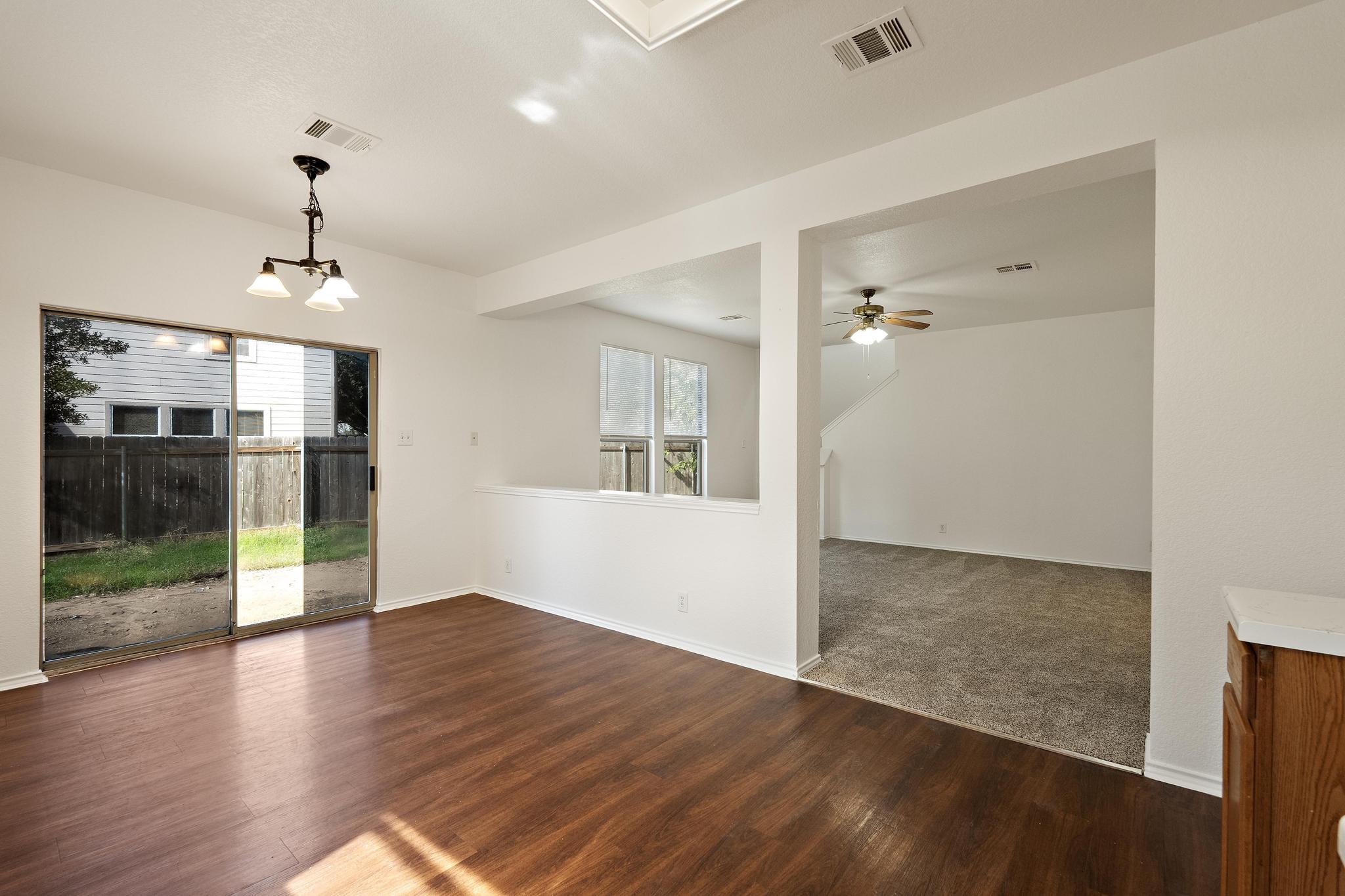 200 Lexington Kyle, TX 78640 - Photo 9 of 25 Spare room with dark wood finished floors, plenty of natural light, and a chandelier