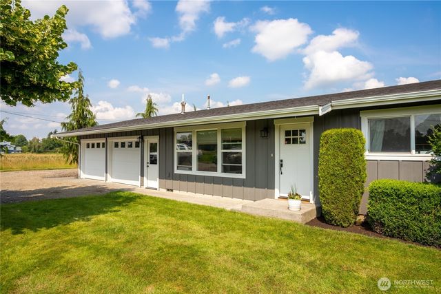 a view of a house with a yard and sitting area