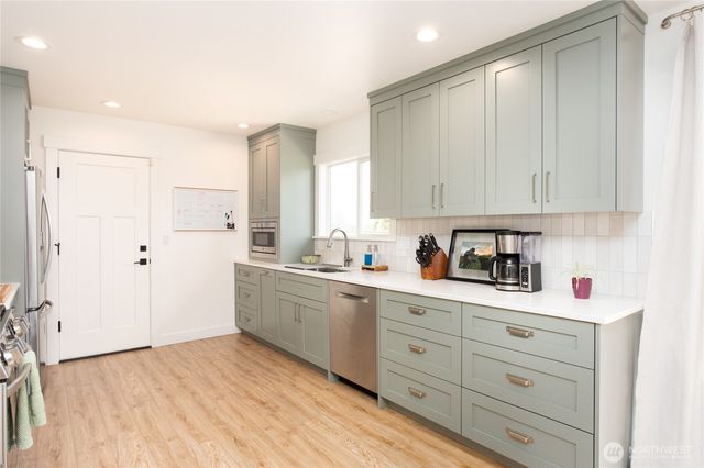 a kitchen with granite countertop white cabinets and white appliances