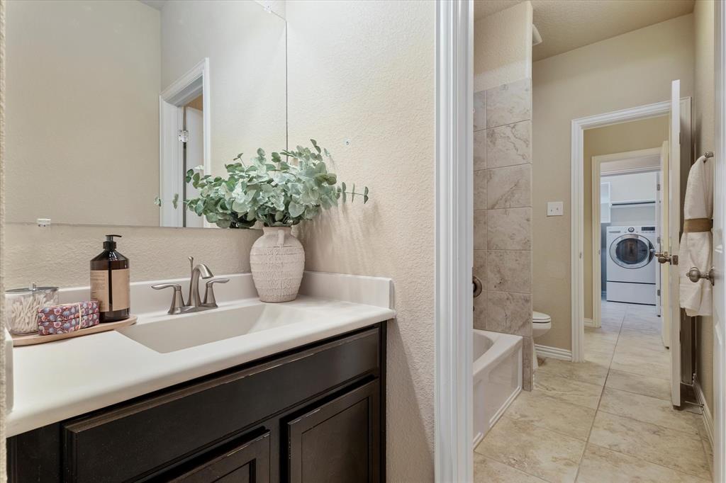 2413 Austin Lane Prosper, TX 75078 - Photo 14 of 32 a bathroom with a sink and a mirror