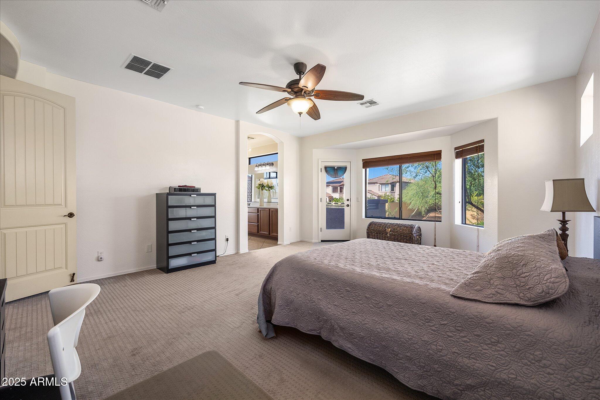 8536 East Inca Street Mesa, AZ 85207 - Photo 19 of 44 a bedroom with a large bed and a chandelier