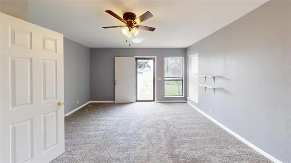 an empty room with windows and cabinet