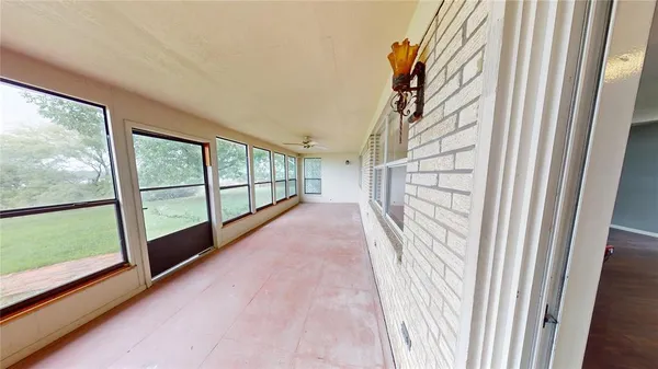a view of a room with wooden floor and windows