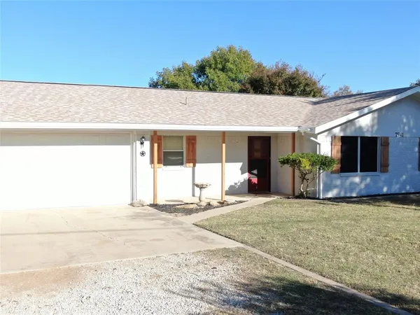 a view of a house with backyard and a garage