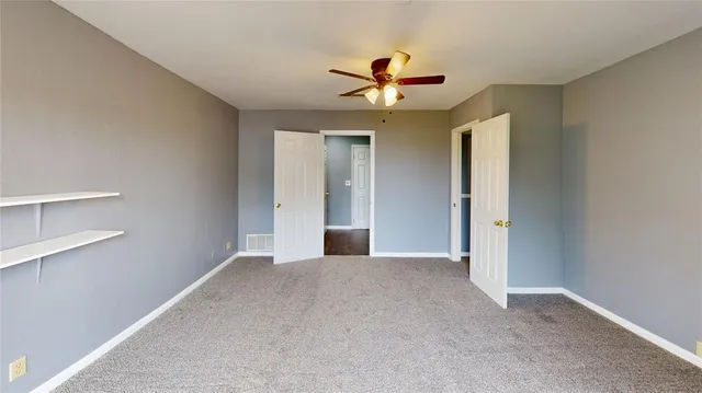 a view of a livingroom with a ceiling fan and window