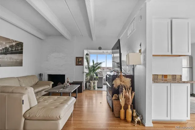 a living room with furniture a chandelier and a wooden floor