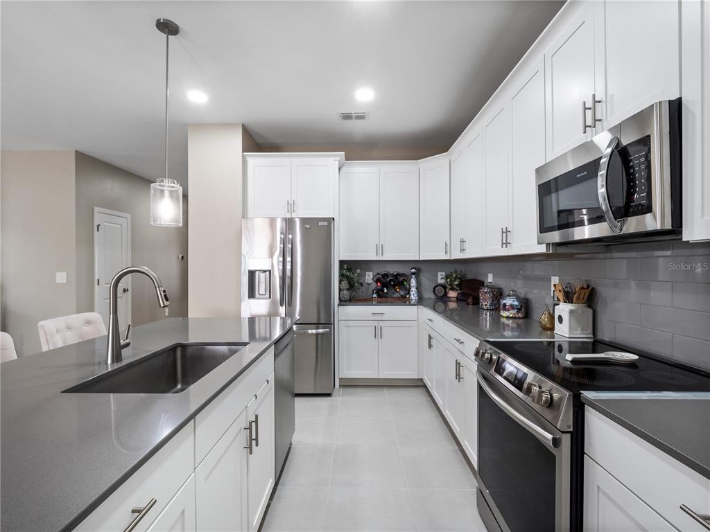 4531 Hillingdam Road Davenport, FL 33837 - Photo 12 of 36 a kitchen with stainless steel appliances granite countertop a sink a stove a refrigerator and cabinets