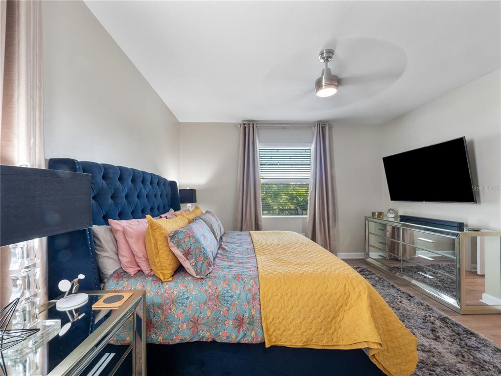 4531 Hillingdam Road Davenport, FL 33837 - Photo 15 of 36 a bedroom with a bed and a flat screen tv