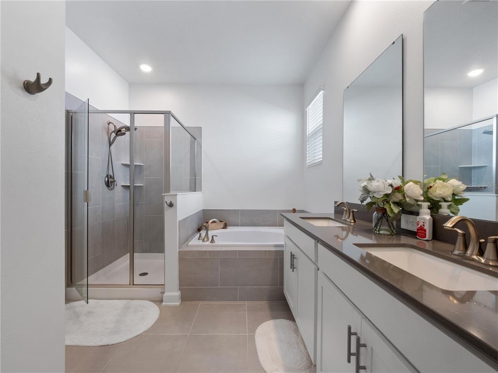 4531 Hillingdam Road Davenport, FL 33837 - Photo 16 of 36 a bathroom with a tub sink and mirror