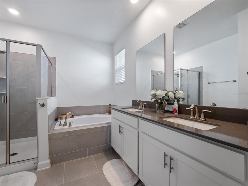 4531 Hillingdam Road Davenport, FL 33837 - Photo 17 of 36 a bathroom with a tub sink and mirror