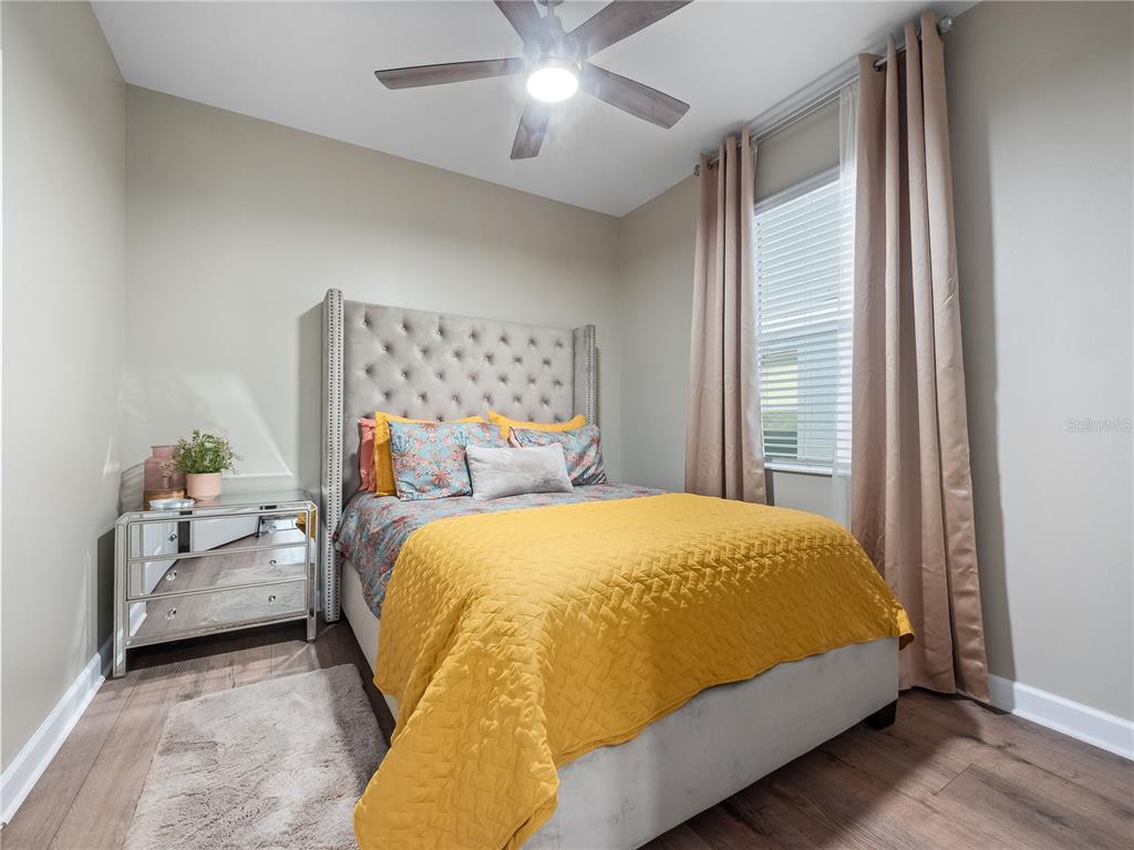 4531 Hillingdam Road Davenport, FL 33837 - Photo 18 of 36 a bed sitting in a bedroom next to a window and a chandelier