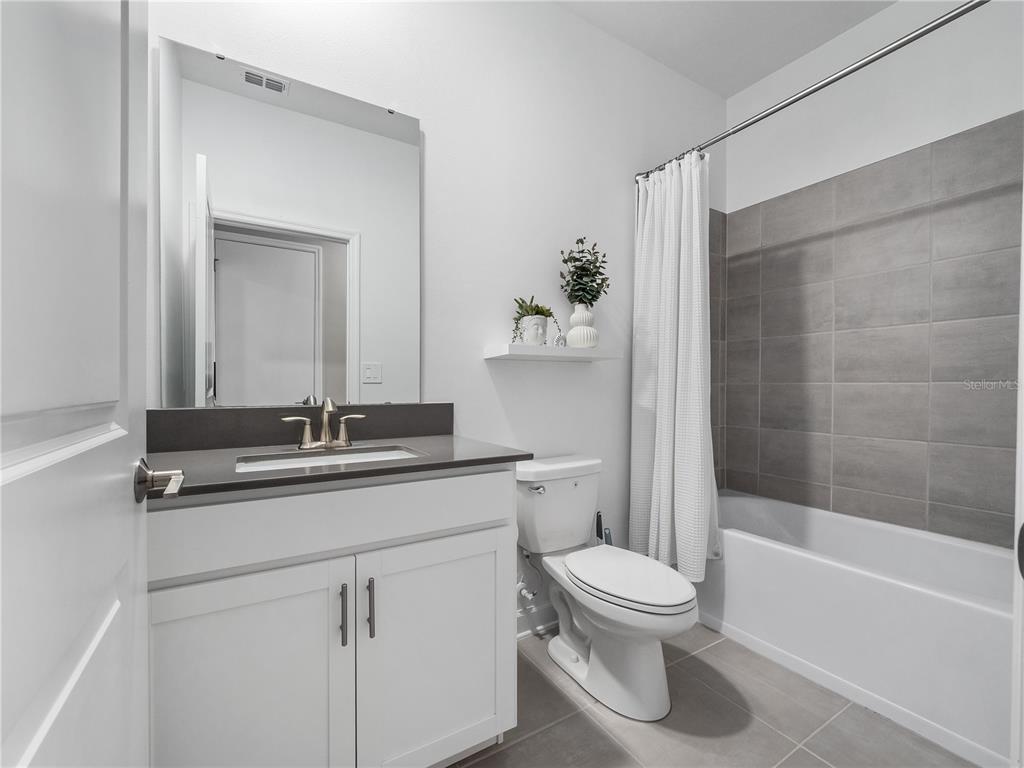 4531 Hillingdam Road Davenport, FL 33837 - Photo 19 of 36 a bathroom with a toilet sink a mirror and shower