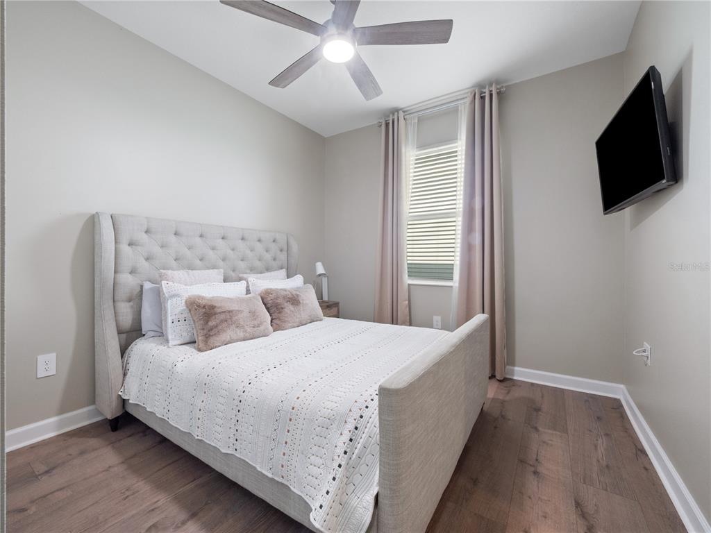 4531 Hillingdam Road Davenport, FL 33837 - Photo 20 of 36 a bedroom with a bed and a flat tv screen on a dresser