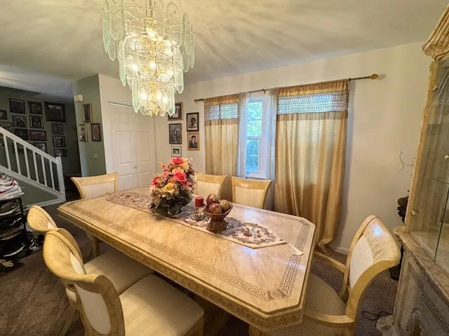 a dining room with furniture a chandelier and window