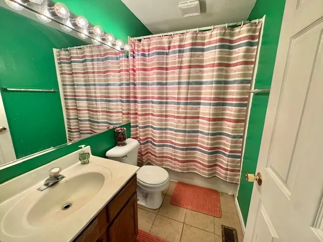 a bathroom with a sink a toilet and shower curtain