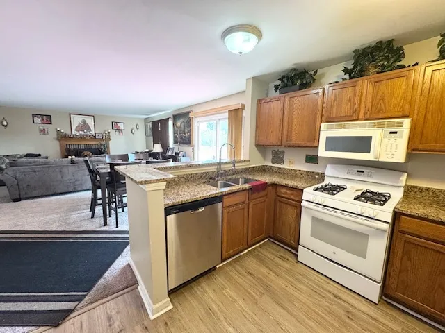 a kitchen with stainless steel appliances granite countertop a stove a sink dishwasher and a refrigerator