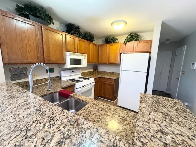 a kitchen with a refrigerator sink stove and wooden cabinets