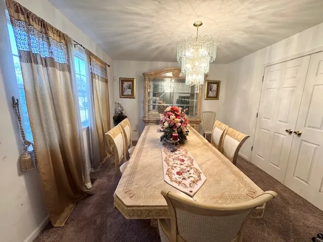 a view of a dining room with furniture and a chandelier