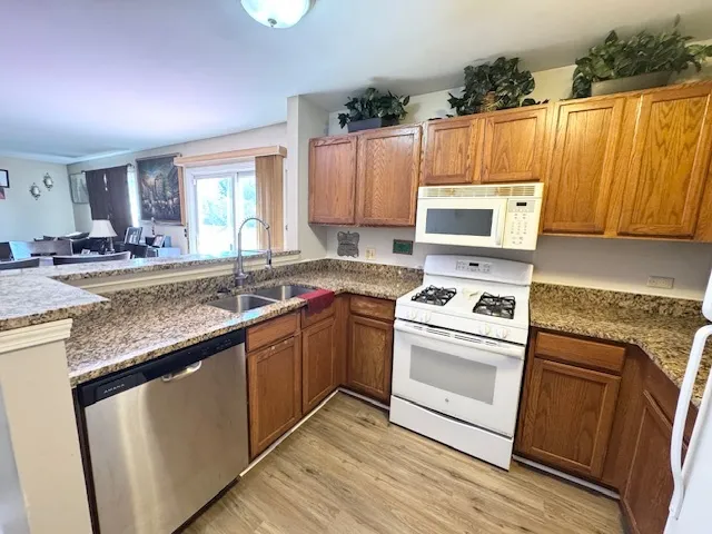 a kitchen with granite countertop a sink stainless steel appliances and cabinets