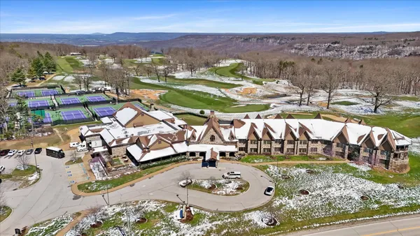 an aerial view of a house with garden space and mountain view in back