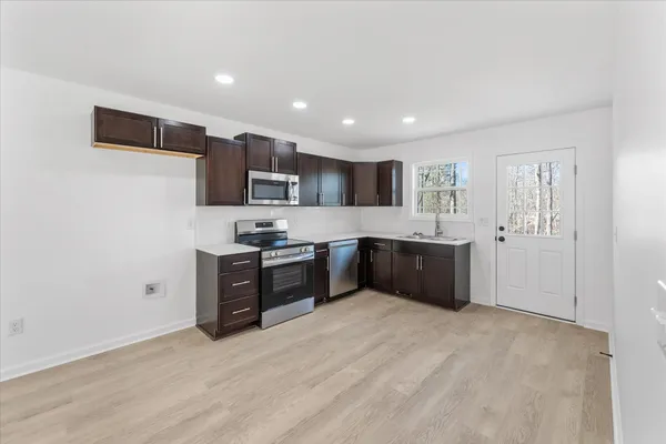 a large kitchen with a refrigerator and a stove top oven