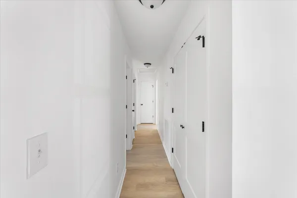 a view of a hallway with wooden floor