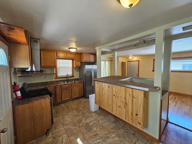 a open kitchen with stainless steel appliances granite countertop a stove a sink and a refrigerator