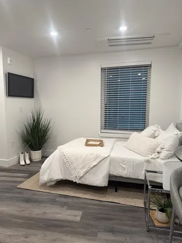 a bedroom with a bed and a potted plant