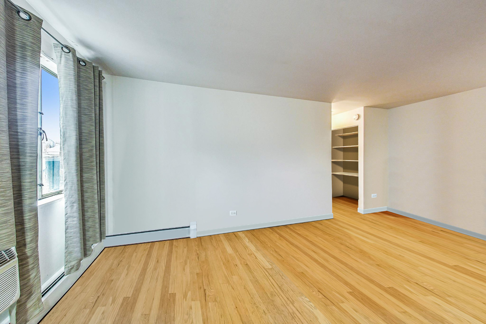 7120 North Sheridan Road, Unit 516 Chicago, IL 60626 - Photo 2 of 6 a view of empty room with wooden floor and fan