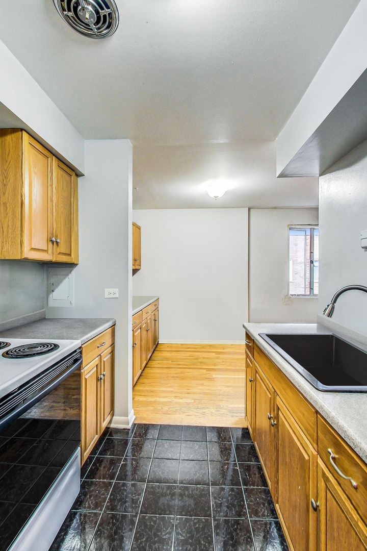 7120 North Sheridan Road, Unit 516 Chicago, IL 60626 - Photo 4 of 6 a kitchen with stainless steel appliances granite countertop a sink and cabinets