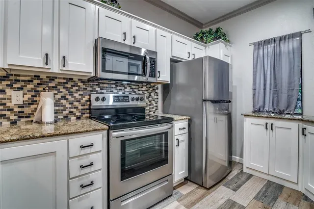 a kitchen with granite countertop cabinets and steel stainless steel appliances