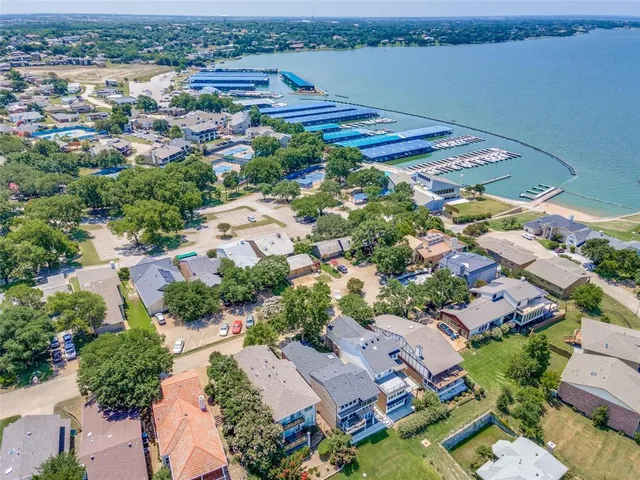 an aerial view of a city with lots of residential buildings ocean and mountain view in back