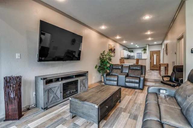 a living room with furniture a flat screen tv and kitchen view