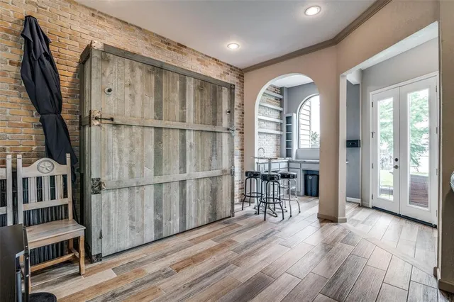 a view of front door with entryway and wooden floor