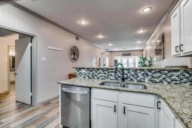 a kitchen with stainless steel appliances granite countertop a sink and a refrigerator