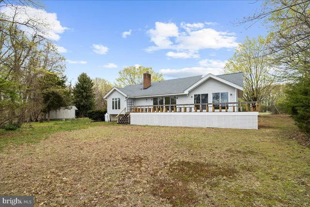 a front view of house with yard and trees in the background