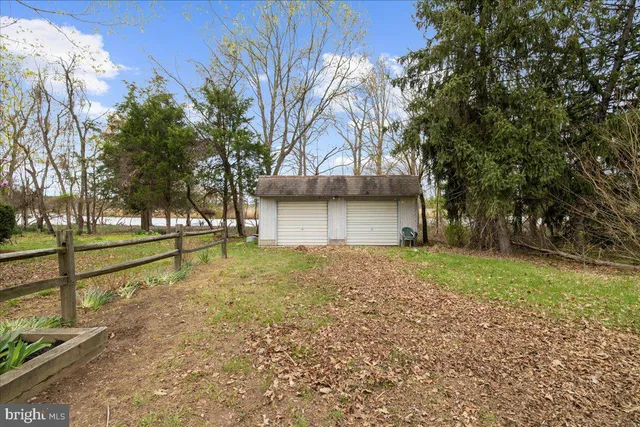 a view of backyard with wooden fence and large trees
